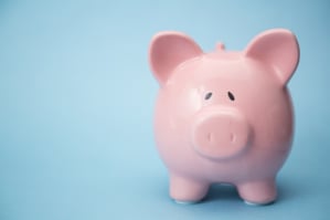 Piggy bank with copy space on blue background